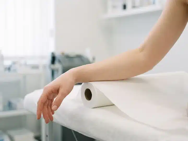 Bras et avant-bras lisses, sans poil, posés sur la table de soin d'un centre My Laser