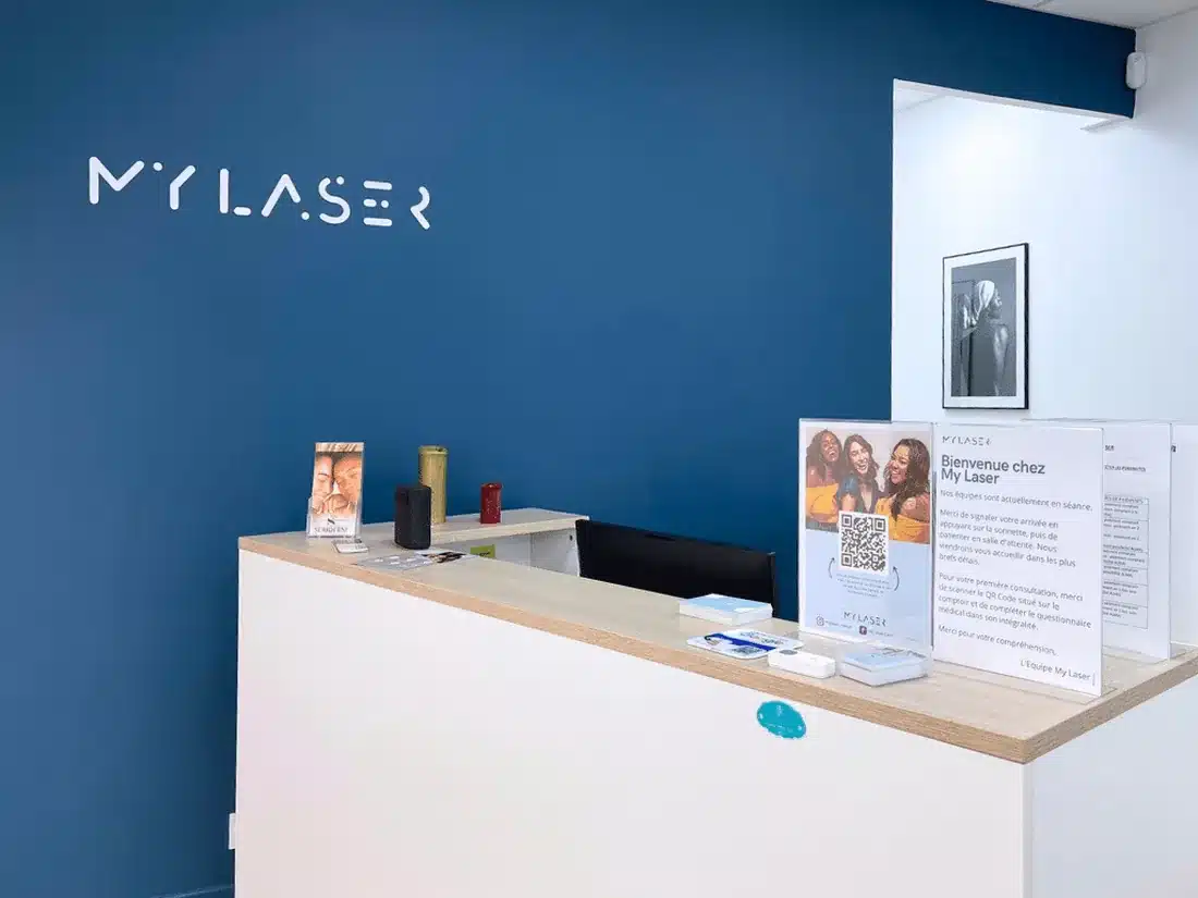 Comptoir d'accueil du centre My Laser Nantes, wordmark My Laser sur le mur marine