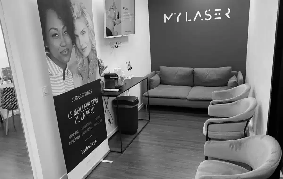 Espace d’accueil d’un centre My Laser avec affiches de soins