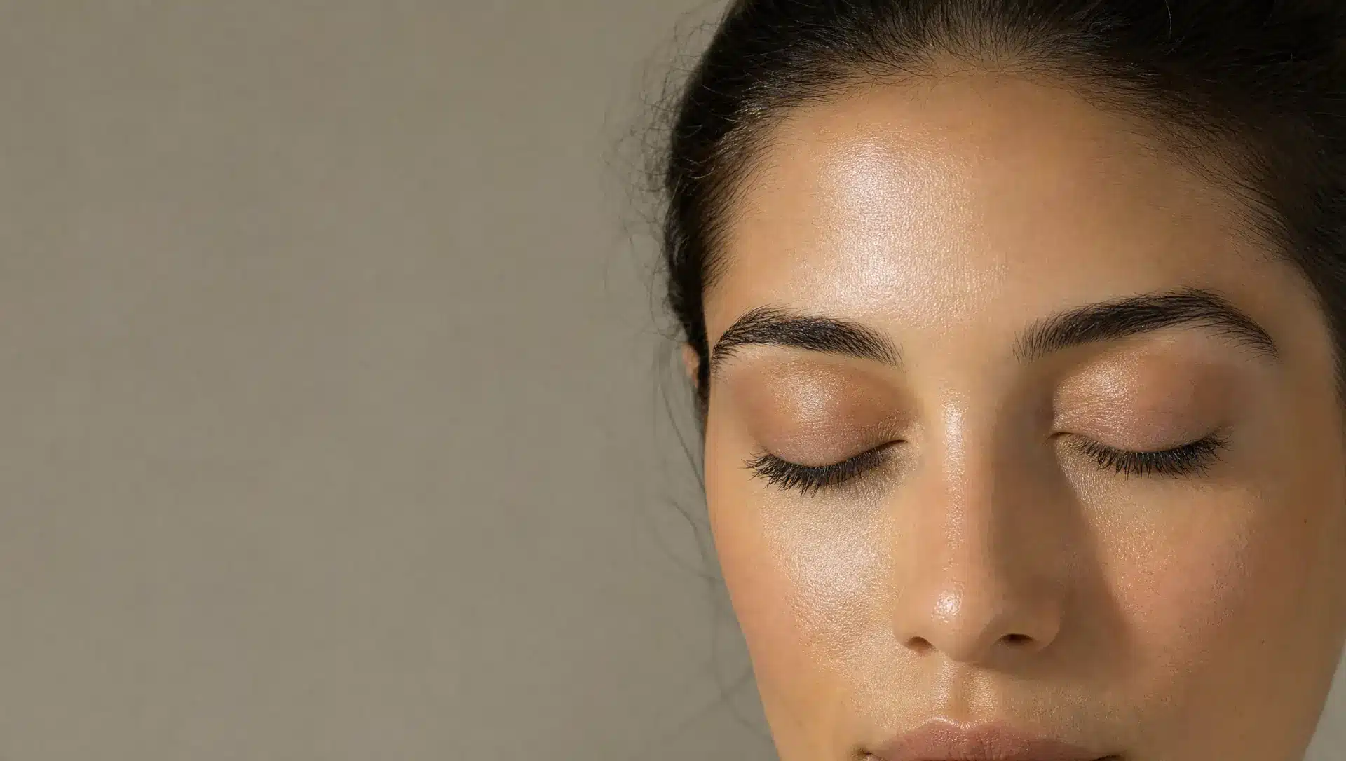Gros plan sur les sourcils et les yeux d'une femme à la peau olive, sourcils nets et soignés, espace entre les sourcils lisse et sans poils, yeux fermés