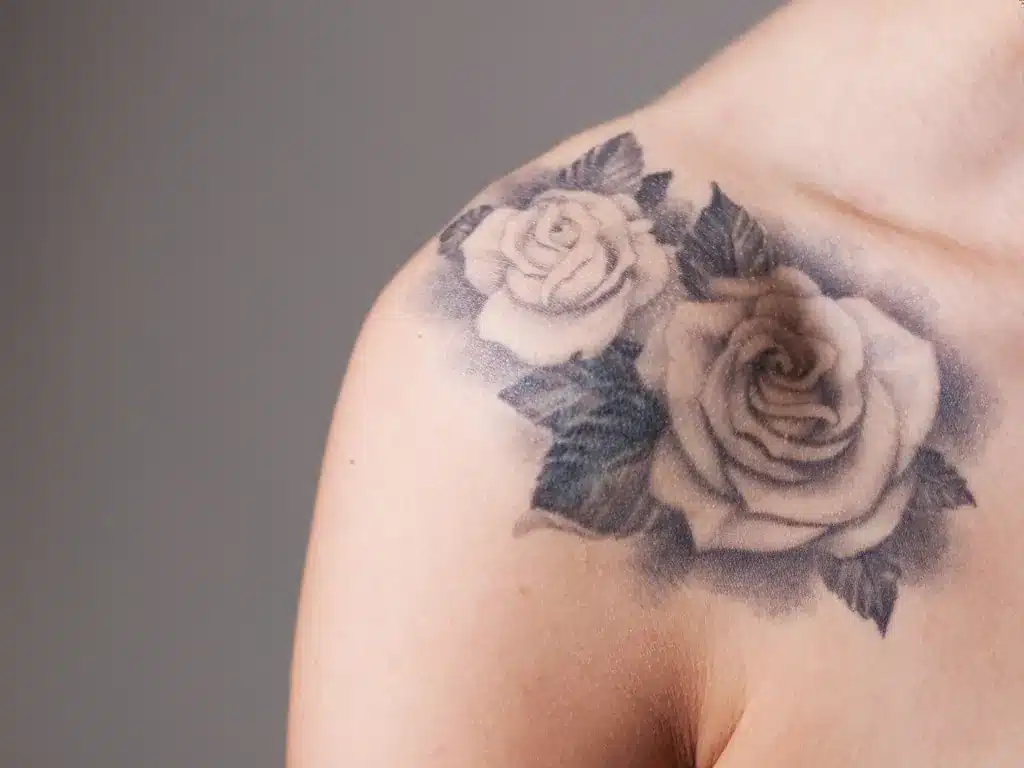 Tatouage de roses en noir et gris sur l'épaule d'une femme